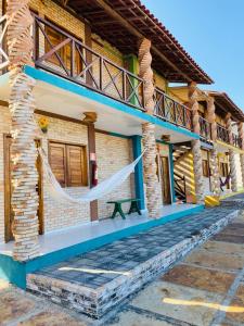 ein Haus mit einer Hängematte draußen in der Unterkunft Pousada Licor de Caju in Barra Grande + 13 Fotos