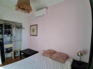 Duplex Climatisé 2chambres Centre Historique في فريجوس: غرفة نوم بها سرير ووسادتين عليه