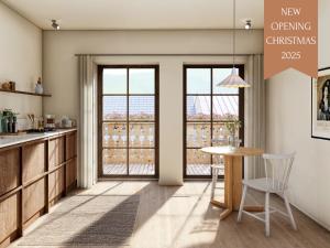 a kitchen with a table and chairs and windows at Karls Design Apartments Mittenwald in Mittenwald
