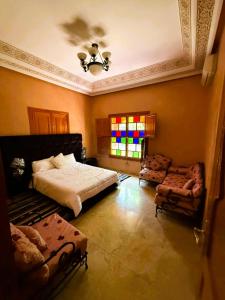 FourouにあるVilla Majidaのベッドとソファと窓のある寝室
