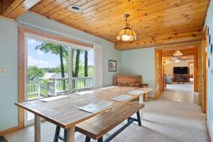 una sala da pranzo con tavolo in legno e ampia finestra di Lakeside Lodge Retreat a Reed City
