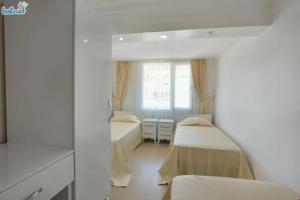 um quarto com duas camas e uma janela em Cem Gül Hotel em Ayvalık
