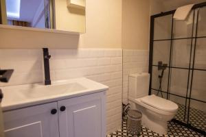 um banheiro com vaso sanitário, pia e chuveiro em Cem Gül Hotel em Ayvalık mais 18 fotografias