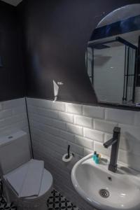 um banheiro com um vaso sanitário, uma pia e um espelho em Cem Gül Hotel em Ayvalık