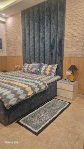 a bedroom with a large bed with a checkered headboard at The Green Door Tricity in Zirakpur