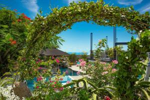 an archway over a pool with flowers at Kokomo Deluxe King - King Cottage in Turtle Cove