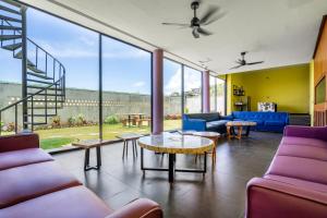 a living room with purple furniture and large windows at Jiya Villa Uluwatu - Panoramic Terraces with Stunning Views, Luxury Service and Entertainment in Uluwatu