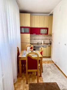 una pequeña cocina con mesa de madera y sillas en Comfy Downtown Apartment Prishtina, en Pristina