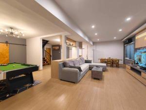 a living room with a couch and a pool table at Sawadee Guesthouse Suvarnabhumi in Lat Krabang