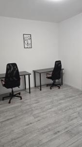 two desks and two chairs in a room at Vila Magurele 2 in Măgurele