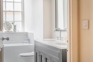 バースにあるStylish 3Bedroom Flat in Bath City Centerのバスルーム(洗面台2台、バスタブ、トイレ付) +3枚の写真
