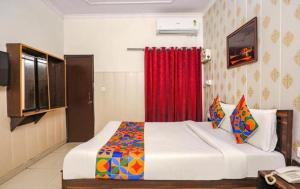 a bedroom with a large bed with a red curtain at Hotel O Lime Wood in Dehradun