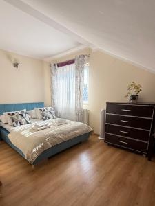 ein Schlafzimmer mit einem Bett, einer Kommode und einem Fenster in der Unterkunft Laura in Bełchatów