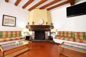 a living room with two couches and a fireplace at Praia da Lota Beachfront Resort - Hotel & Apartments in Manta Rota