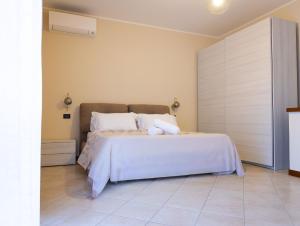 a bedroom with a bed with white sheets and pillows at Civico 5 in Piacenza