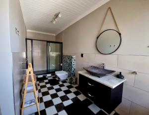 a bathroom with a sink and a mirror on the wall at Stay at 64 Omeya in Windhoek +15 photos