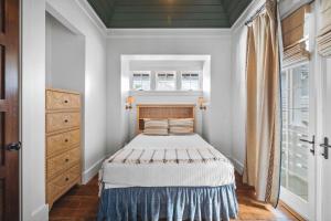 a small bedroom with a bed and a window at Sadie's Cottage in Rosemary Beach +123 photos