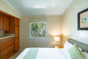 a bedroom with a white bed and a window at Kokomo Classic 2 Bedroom Couples Cottage in Turtle Cove +7 photos