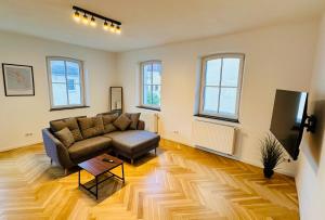 a living room with a couch and a tv at Ferienwohnungen Luitpold - Boutique Apartments in Dinkelsbühl