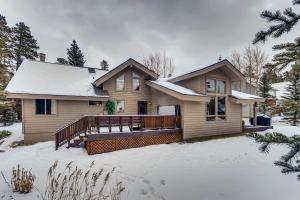 a house with a large deck in the snow at Lazy Bear in Breckenridge