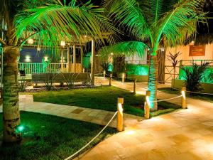a courtyard with two palm trees and lights at Elohim Beach Flats - Fortim - Praia Pontal de Maceió in Fortim
