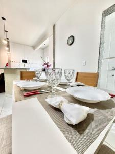 a dining room table with plates and glasses on it at Ape Elegance com ar condicionado cama queen no centro in Formosa +39 photos