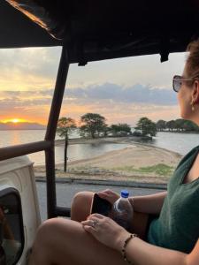 uma mulher sentada num barco a olhar para a água em Nature's peak Udawalawa em Nikawatawana