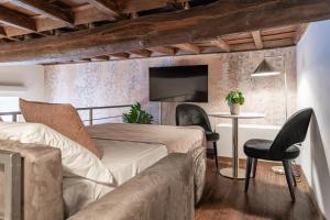 a bedroom with a bed and a couch and a table at Lussuose Suite con Spa Privata a Grottaferrata - Rooms 1-2 in Grottaferrata
