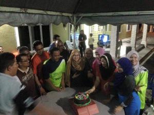 een groep mensen die rond een tafel met een taart staan bij D'Pantai Homestay Kuala Sg. Baru in Melaka