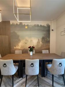 ein Esszimmer mit einem Holztisch und Stühlen in der Unterkunft Laura in Bełchatów