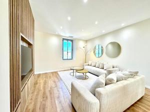 Una sala de estar con un sofá y un televisor. en Le Prestigieux - Appartement de Charme en Plein Centre-Ville - Billard - Salle Polyvalente - Terrasse - Piscine & Parking Privé - Proche A7, en Orange