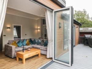 a living room with a couch and a glass door at 7 Lake View in Troutbeck Bridge