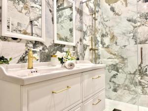 Un baño blanco con lavabo y ducha. en Le Prestigieux - Appartement de Charme en Plein Centre-Ville - Billard - Salle Polyvalente - Terrasse - Piscine & Parking Privé - Proche A7, en Orange