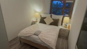 a bed in a bedroom with two lamps and a window at Gabriel in Sankt Augustin