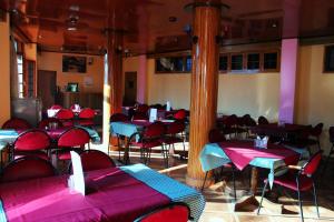 a dining room with tables and chairs and pink tables at Hotel Aroma Classic in Kulu