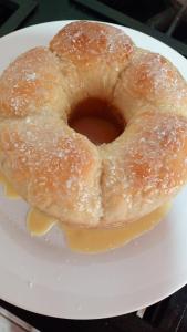 a glazed donut sitting on a white plate at Hotel Vale do Sol in Valparaíso