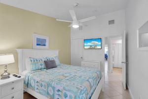 une chambre avec un lit et un ventilateur de plafond dans l'établissement Waterfront luxury Villa 14 with spectacular sunset views and boat slip townhouse, à Marathon