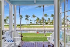 une véranda avec vue sur l'eau et les palmiers dans l'établissement Waterfront luxury Villa 14 with spectacular sunset views and boat slip townhouse, à Marathon