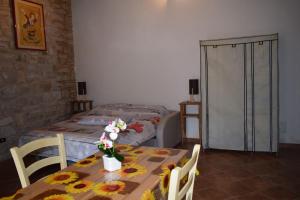 a room with two beds and a table with flowers on it at B&B Guado di Pio- monolocale in Il Guasto