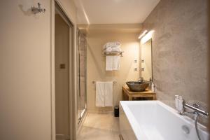 een badkamer met een groot bad en een wastafel bij Moulin de Cambelong- Emilie & Thomas in Conques-en-Rouergue +49 foto's