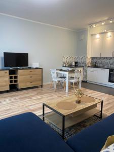 een woonkamer met een tafel en een keuken bij Good Time Apartments 104 Komfortowy apartament w sercu Starego Miasta in Poznań