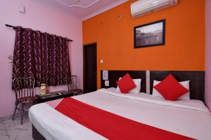 a bedroom with a large bed with red pillows at Hotel O Haveli Inn in Varanasi