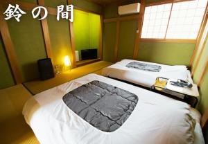 a hotel room with two beds and a television at 鈴籠城 城の間 in Nagahama +13 photos