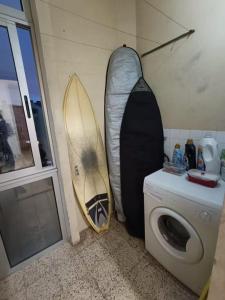 two surfboards leaned up against a wall next to a washing machine at Amadora Pet Apartment in Amadora