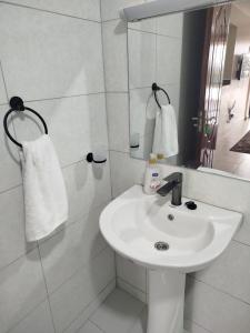 a white bathroom with a sink and a mirror at Lakeview Apartments - The Nest in Mbita