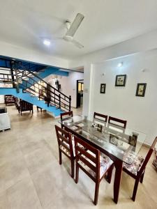 a dining room with a glass table and chairs at Marvella 3BHK Luxury Villa with Shared Pool in Arpora