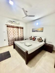 a bedroom with a bed with a ceiling fan at Marvella 3BHK Luxury Villa with Shared Pool in Arpora