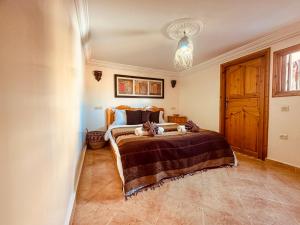 ein Schlafzimmer mit einem Bett und einem Kronleuchter in der Unterkunft Tayafut Apartments & Terrace by Surfleft Morocco in Mirleft
