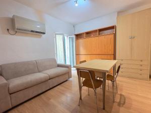 a living room with a couch and a table at MiniMa - By Ligooria in Pietra Ligure