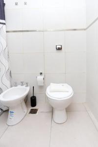 a white bathroom with a toilet and a sink at Departamento a estrenar centro-sur Santa Fe - Urquiza II in Santa Fe +8 photos